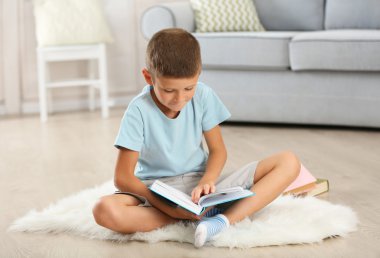 Halı, eve iç arka plan üzerinde oturup kitap ile küçük çocuk