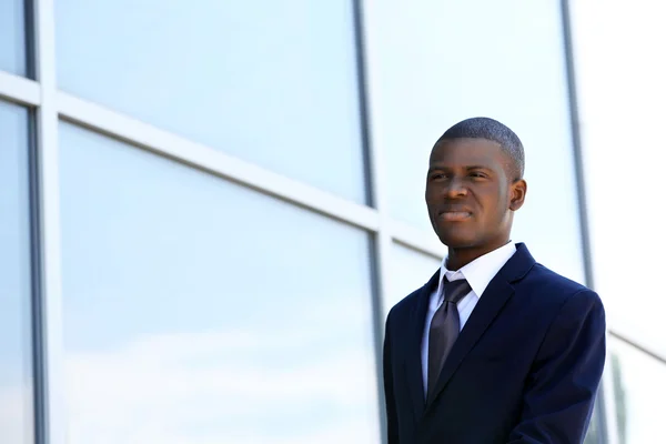 Handsome African American businessman with newspaper near business centre — Stock Photo, Image