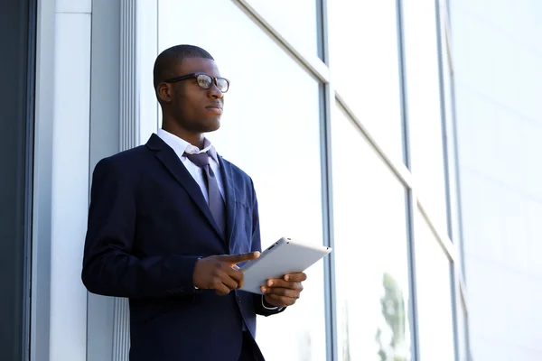 Handsome African American businessman with digital tablet near business centre — Stock Photo, Image