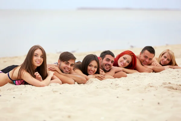 Young people lying on beach — Stock Photo, Image