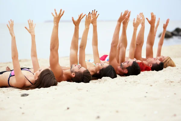 Young people lying on beach — Stock Photo, Image