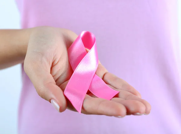 Pink ribbon in woman's hands — Stock Photo, Image