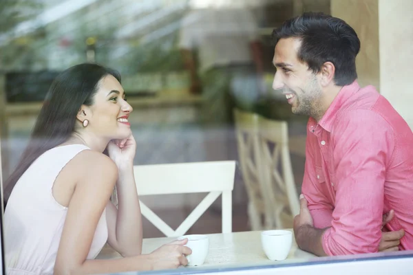 Young couple drinking tea and talking in cafe — Stock Photo, Image