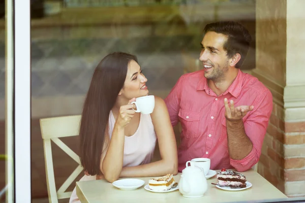 Jovem casal bebendo chá e conversando no café — Fotografia de Stock