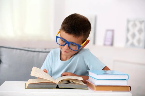 Menino sentado no sofá com livro, em casa fundo interior — Fotografia de Stock