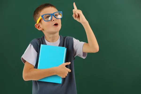 Prachtige kleine jongen op blackboard achtergrond — Stockfoto