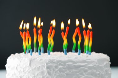 koyu arka plan üzerinde mumlarla doğum günü pastası