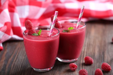 Ahşap masa üzerinde çilek ile Ahududu milkshake bardak yakın çekim