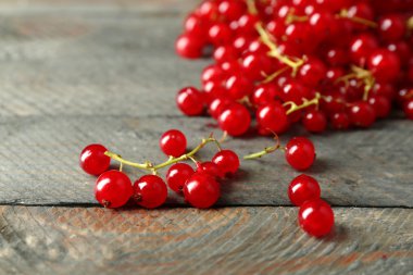 Ahşap arka plan üzerinde olgun kırmızı kuş üzümü