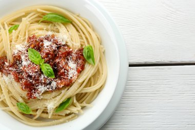 Spagetti Bolognese renk ahşap arka plan üzerinde beyaz kase parmesan peyniri ile