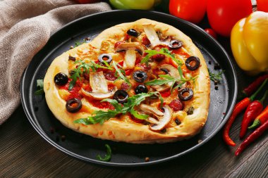 Pizza ahşap arka plan üzerinde metal tepsi üzerinde kalp şeklinde
