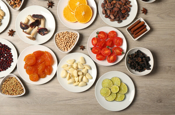 Different products on saucers on wooden table, top view