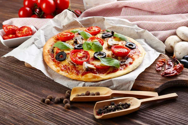 Leckere Pizza mit Gemüse und Basilikum auf dem Tisch aus nächster Nähe — Stockfoto