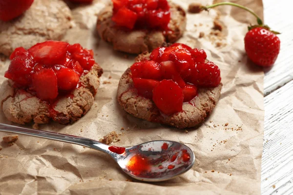 Cookies with fresh strawberry on crumpled parchment, closeup — Stock Photo, Image