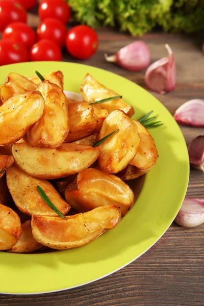 Baked potato wedges on wooden table, closeup — Stock Photo, Image