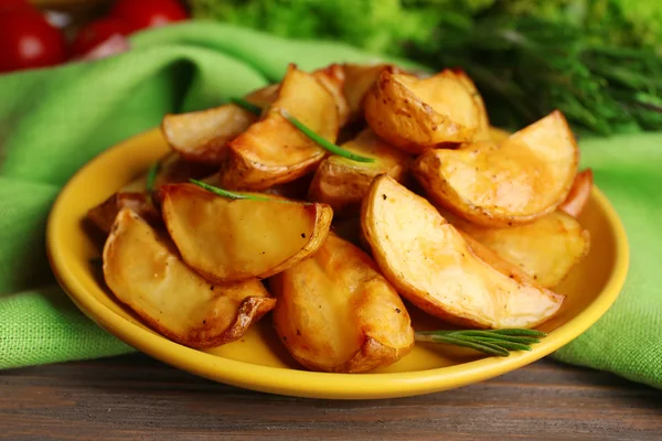 Pieczone ziemniaki klinów na drewnianym stole, zbliżenie — Zdjęcie stockowe