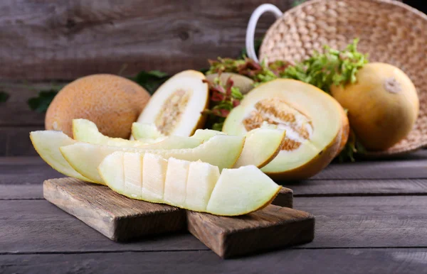 Rijpe meloenen met groene bladeren op tafel close-up — Stockfoto