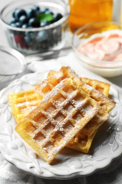 Süße hausgemachte Waffeln auf Teller, auf farbigem Holzhintergrund — Stockfoto