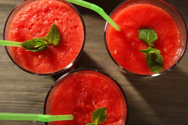 Glasögon av vattenmelon juice på träbord, ovanifrån — Stockfoto
