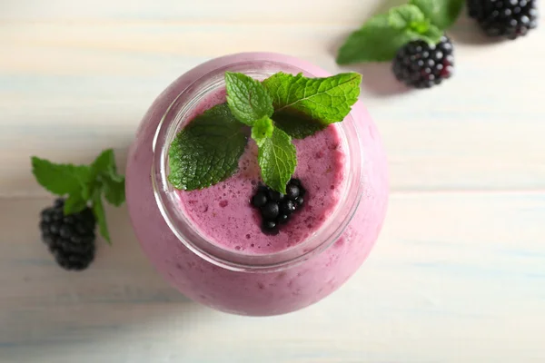 Delicious berry smoothie with blackberries on wooden table close up — Stock Photo, Image