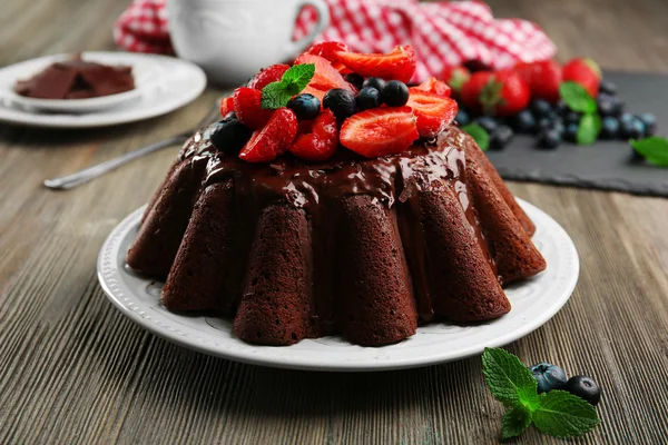 Deliziosa torta al cioccolato con bacche in piatto sul tavolo, primo piano — Foto Stock