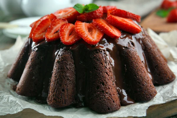 Heerlijke chocolade cake met bessen in plaat op tafel, close-up — Stockfoto