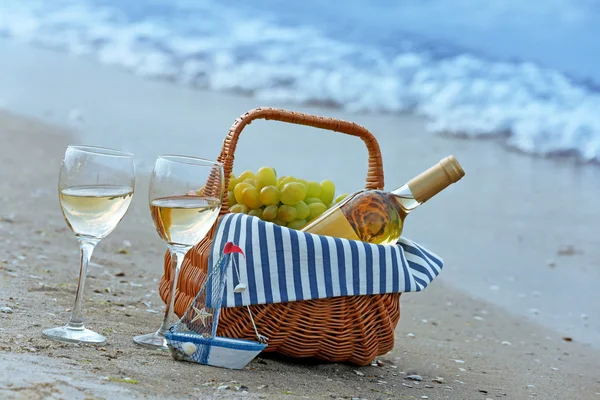 与瓶酒在沙滩上野餐篮子 — 图库照片