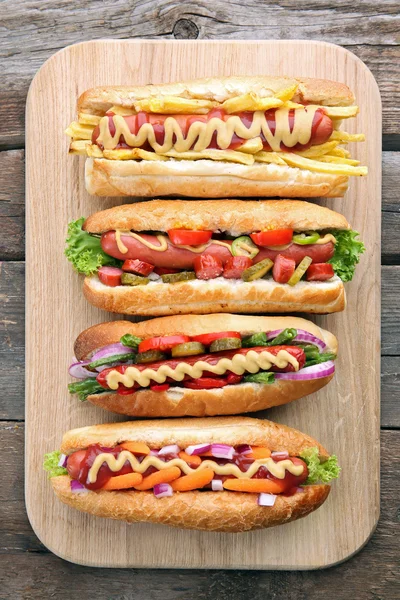Hot dogs frais sur planche à découper sur fond en bois — Photo