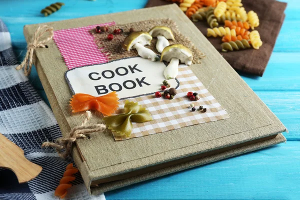Decorated cookbook on blue wooden background — Stock Photo, Image