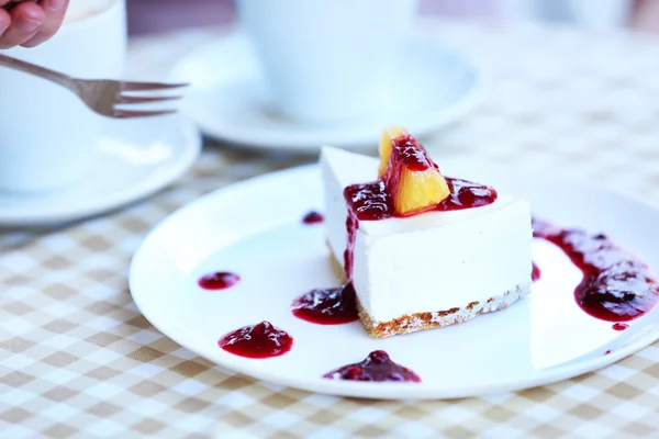 Délicieux gâteau au fromage avec sauce sur la table dans le café — Photo