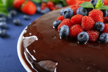 Mavi masa örtüsü, closeup üzerinde yaz meyveleri lezzetli çikolatalı kek