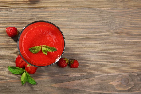 Glas strawberry smoothie met bessen op houten tafel close-up — Stockfoto