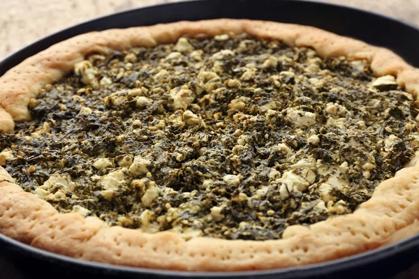 Open pie with spinach close up