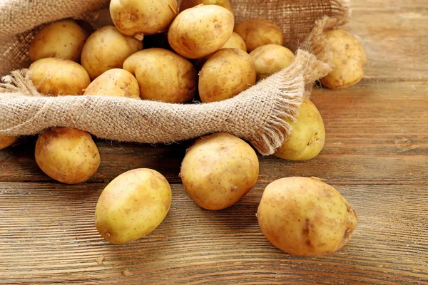 Batatas jovens na mesa de madeira perto — Fotografia de Stock