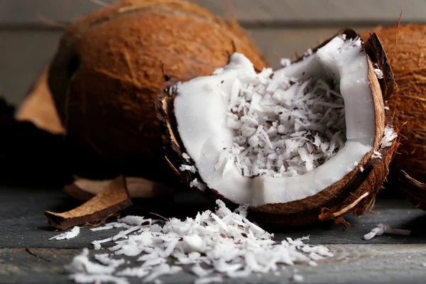 Kokosové hobliny v kokosu na dřevěné pozadí — Stock fotografie