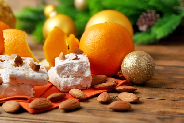 Süßes Nougat mit Orangen und Weihnachtsdekoration auf dem Tisch aus nächster Nähe — Stockfoto