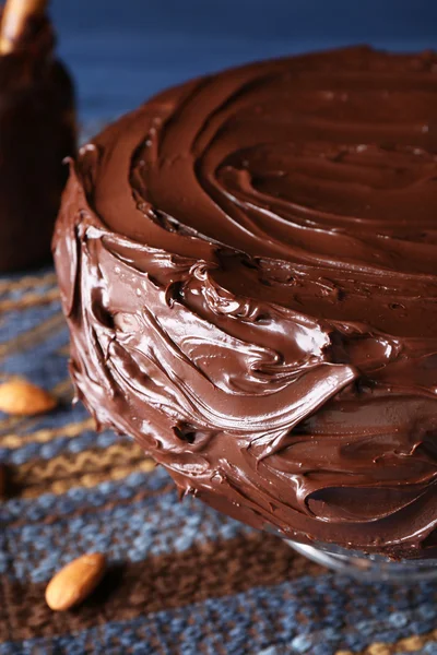 Smakelijk chocoladetaart onder amandelen op blauwe achtergrond — Stockfoto