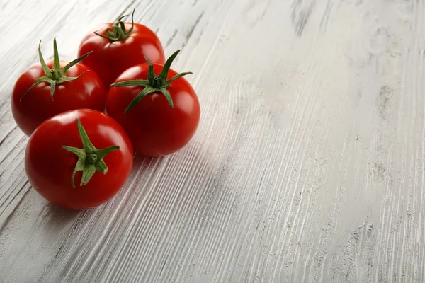 Tomates vermelhos em fundo de madeira — Fotografia de Stock