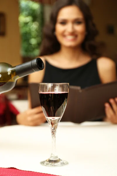 Mladá krásná žena v restauraci. Číšník nalil víno ve sklenici — Stock fotografie