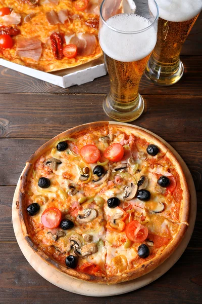 Pizza mit Bier auf Holztisch serviert — Stockfoto
