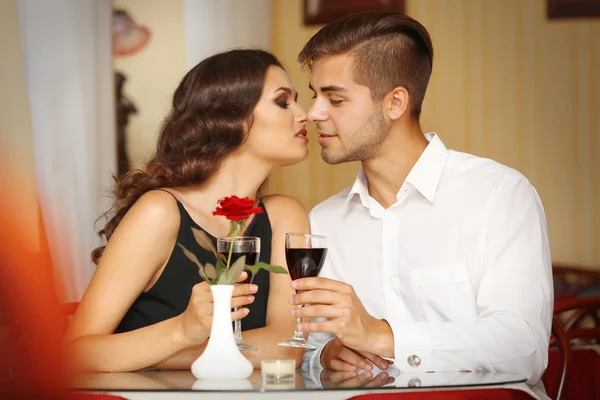 Young attractive lady kisses her beloved man at the restaurant Stock Image