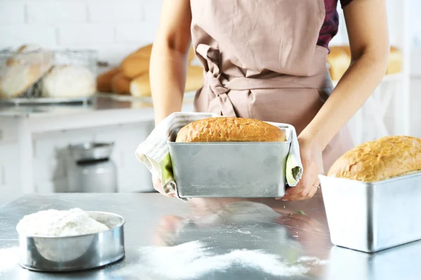 Bäcker überprüft frisch gebackenes Brot in Bäckereiküche — Stockfoto