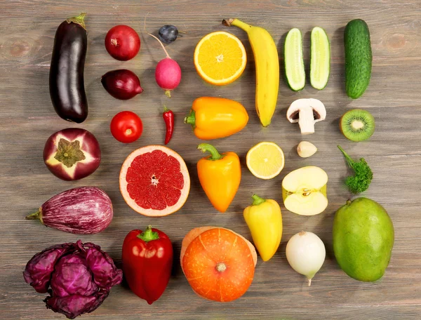 Frutas e legumes diferentes no fundo de madeira — Fotografia de Stock