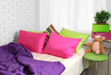 Yatak odasında renkli yastıklar ile rahat yatak