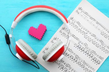 Mavi ahşap arka plan üzerinde müzik notaları ile kulaklıklar