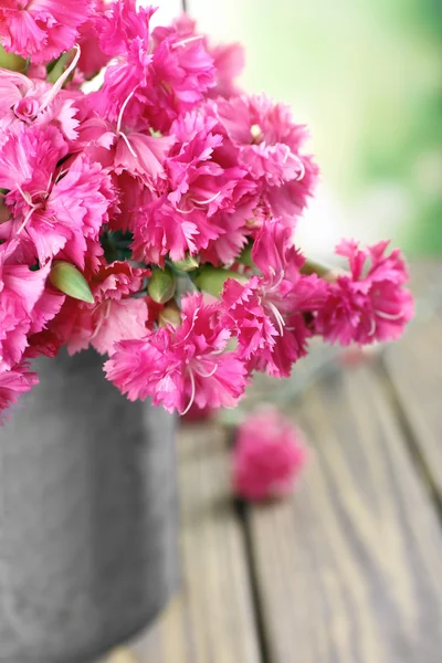 Mooi boeket van roze anjer in gieter op lichte achtergrond — Stockfoto