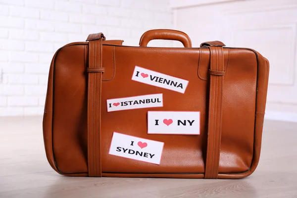Suitcase with stickers on floor in room — Stock Photo, Image