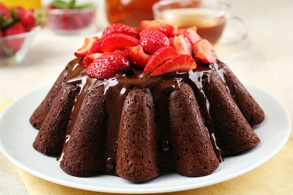 Tasty chocolate muffin with glaze and berries on table close up — Stock Photo, Image