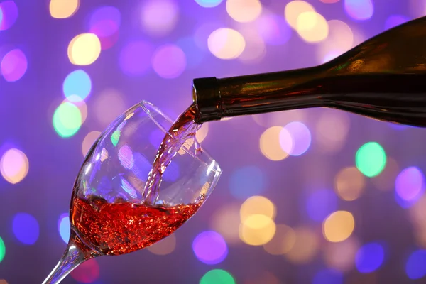 Вино наливается в стекло на ярком фоне — стоковое фото