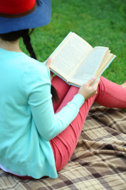 kitap yeşil çimenlerin üzerinde oturan kadınla